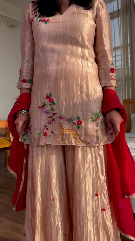 Graceful Peach Sharara Set with Delicate Floral Embroidery, Flared Palazzo Bottoms, and Contrasting Red Dupatta