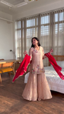 Graceful Peach Sharara Set with Delicate Floral Embroidery, Flared Palazzo Bottoms, and Contrasting Red Dupatta