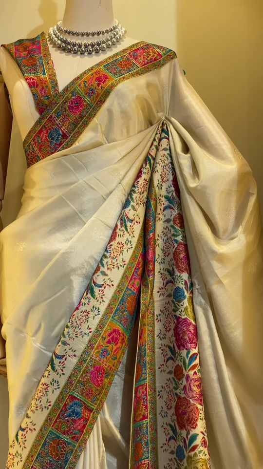 Elegant Cream Banarasi Silk Saree with Multicolor Floral Jaal Weaving, Rich Contrasting Zari Border, Traditional Pallu Design, and Intricate Meenakari Detailing Perfect for Festivals, Weddings, and Cultural Celebrations